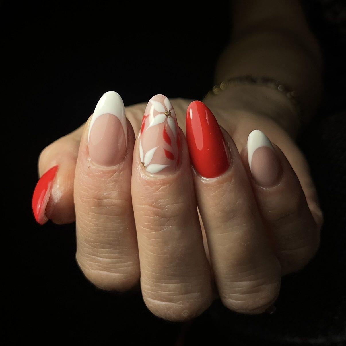 Gelnagels met French tips, rode nagels en een handgeschilderde bloem